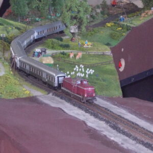 Modelleisenbahnanlage mit detaillierter Miniaturlandschaft, Zügen, Bäumen und Tierfiguren